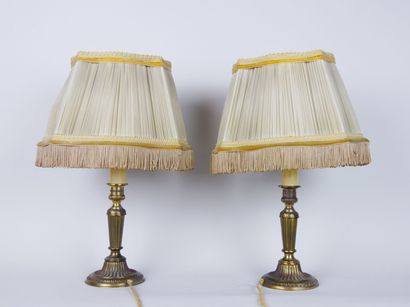 null Pair of gilded brass lamps, the shaft decorated with gadroons resting on a circular...