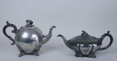 null Set of two silver plated teapots with foliage decoration, the handles resting...