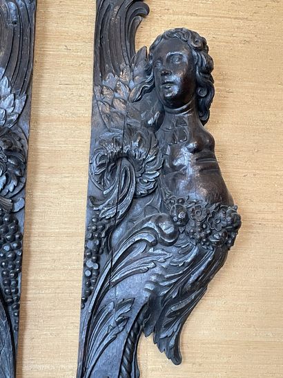 null Two jambs forming a pendant in carved and stained oak decorated with cherubs...