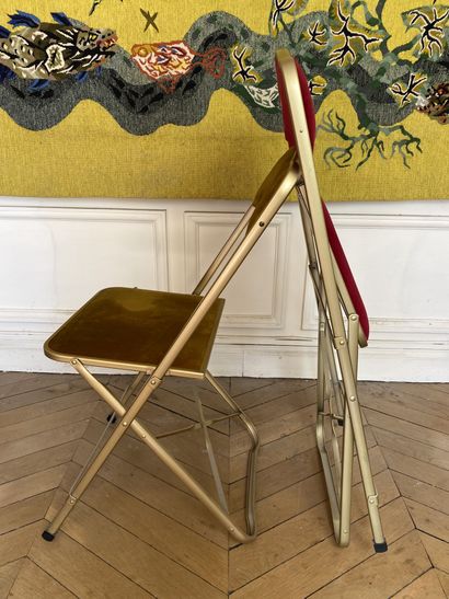 null Suite de 10 chaises pliantes en métal doré garnies de velours mordoré ou rouge....