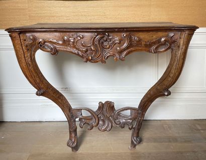 null A molded and carved walnut console with rocaille and foliage decoration. The...