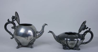 null Set of two silver plated teapots with foliage decoration, the handles resting...