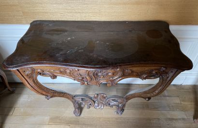 null A molded and carved walnut console with rocaille and foliage decoration. The...