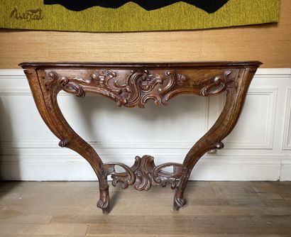 null A molded and carved walnut console with rocaille and foliage decoration. The...