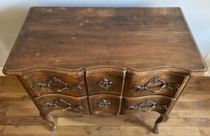 null Walnut chest of drawers opening to two drawers in front of a crossbow, resting...