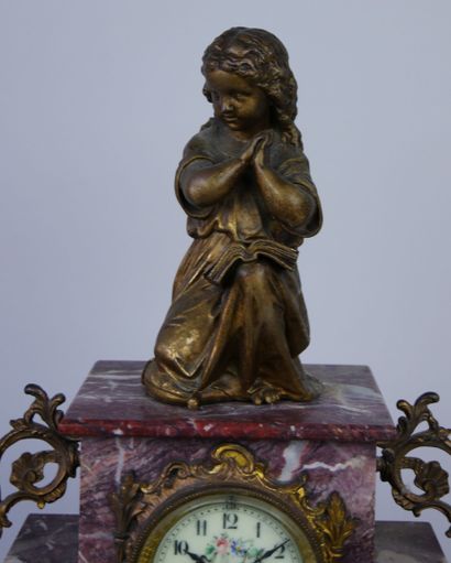 null Mantel clock in red veined marble surmounted by a praying child in gilded metal....