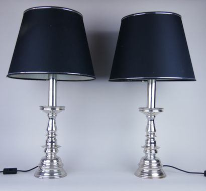 Pair of silver plated metal torches resting...