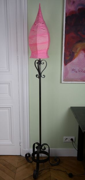 null Wrought iron floor lamp decorated with scrolls resting on a tripod base with...
