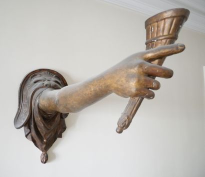 null Carved wood and stucco polychrome and gilded torch holder featuring an arm holding...