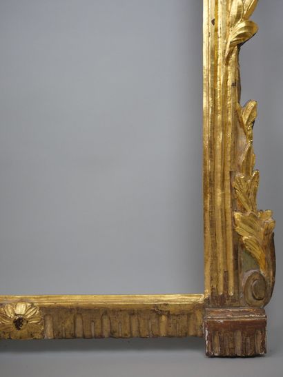 null Framed glass in carved and gilded wood, the pediment decorated with gardening...