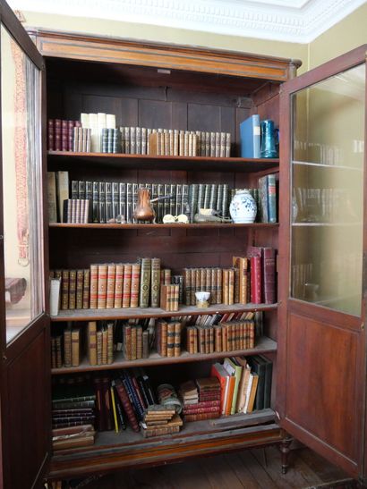 null Bookcase in mahogany underlined by brass rods, opening by two partly glazed...
