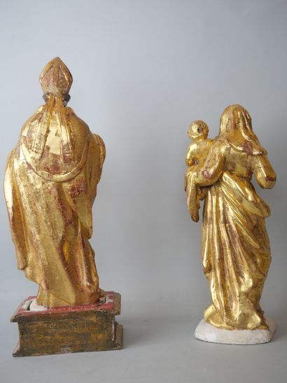 null Two statuettes in carved wood and partially gilded including : 

A Virgin and...