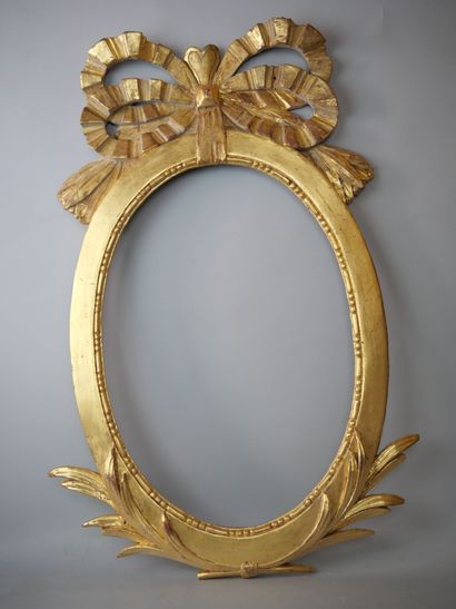 Oval frame in carved and gilded wood, topped...