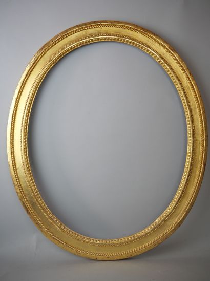 Oval frame in carved and gilded wood, decorated...