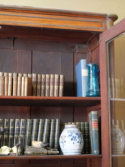 null Bookcase in mahogany underlined by brass rods, opening by two partly glazed...