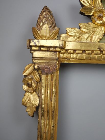 null Framed glass in carved and gilded wood, the pediment decorated with gardening...