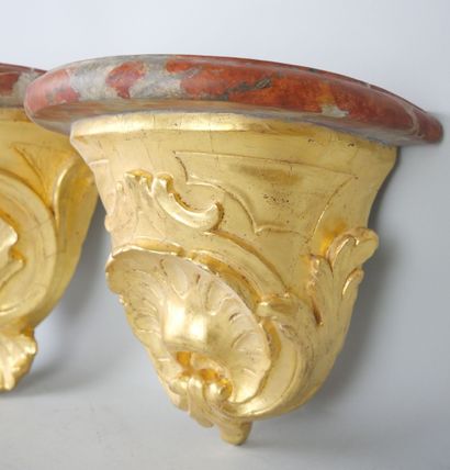 null Pair of carved and gilded wood sconces, the tops painted in trompe-l'oeil.

Eighteenth...