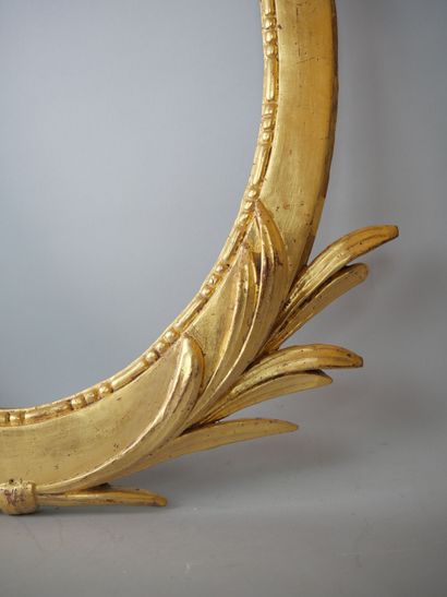 null Oval frame in carved and gilded wood, topped with a large ribbon knot, and palms.

19th...