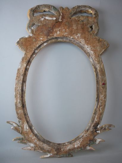 null Oval frame in carved and gilded wood, topped with a large ribbon knot, and palms.

19th...