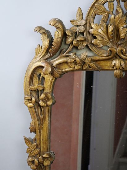 null Rectangular mirror in carved and gilded wood on a green background decorated...
