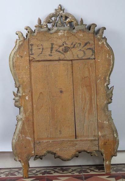 null Rectangular mirror in carved and gilded wood on a green background decorated...