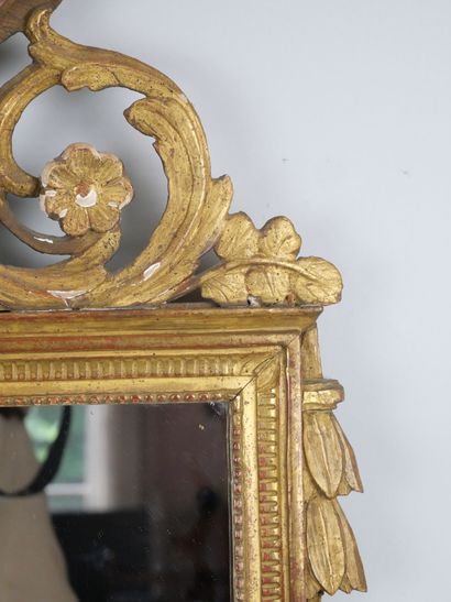 null A molded wood pediment mirror of rectangular shape, carved and gilded with a...