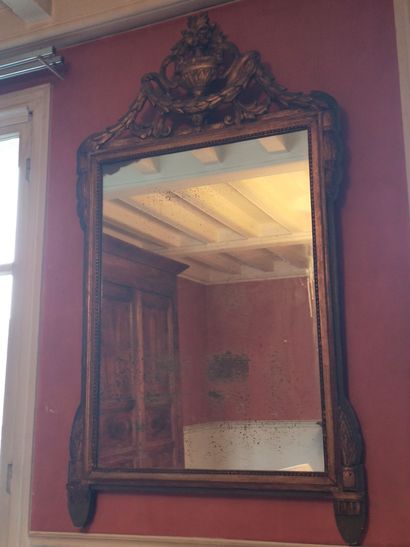 null Miroir en bois sculpté et doré, le fronton à décor ajouré d'une vasque fleurie...