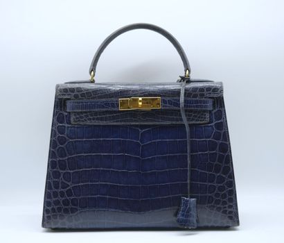 null HERMES PARIS
Sac KELLY en crocodile bleu marine, avec cadenas pochette et bandoulière.
(Usure...