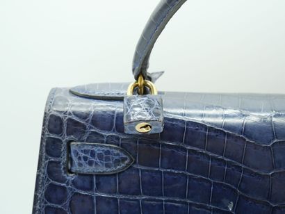 null HERMES PARIS
Sac KELLY en crocodile bleu marine, avec cadenas pochette et bandoulière.
(Usure...