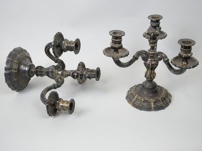 null Pair of candlesticks in silver plated metal, the base with curved edges, the...