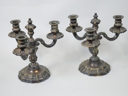 null Pair of candlesticks in silver plated metal, the base with curved edges, the...