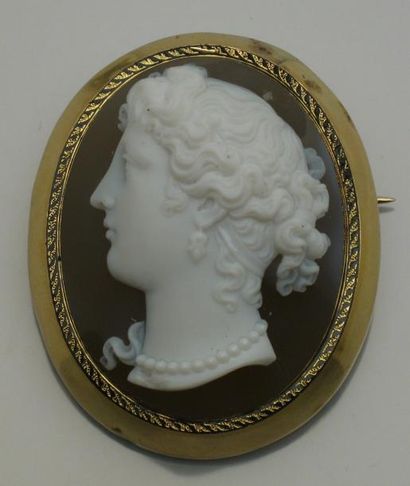 null Broche en or jaune ornée d'un camée de profil de femme. H : 4 cm. Poids brut...