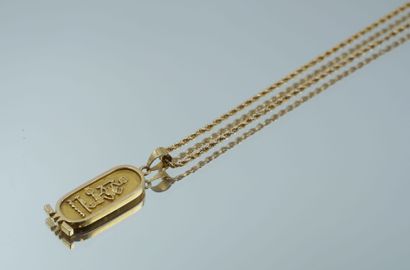 null Long, twisted-link chain in 750 thousandths gold holding an Egyptian cartouche...