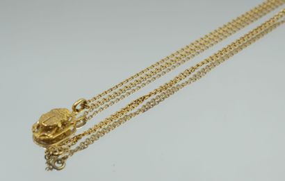 null Long 750 thousandths gold chain holding a 750 thousandths gold scarab pendant
Chain...