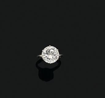  Bague en or blanc 18K (750/1000e), ornée au centre d'un diamant rond de taille brillant...