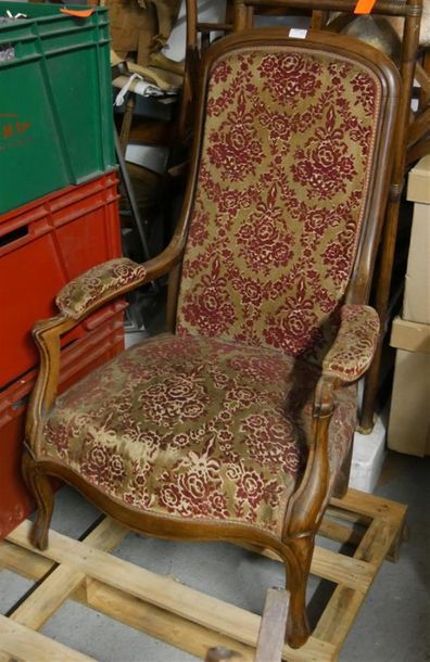 null Un fauteuil Voltaire en bois naturel mouluré. Garniture velours fleurs rouges...