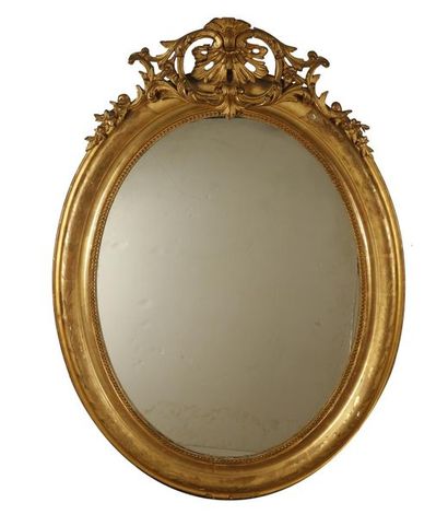 MIROIR Miroir de forme ovale en bois doré et sculpté de fleurettes, coquilles et...