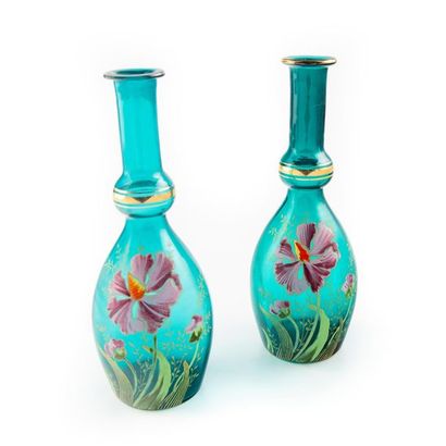 null Pair of green glass bottle-shaped carafes with enamel and gold flower decoration.
Circa...