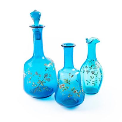null Covered bottle-shaped carafe in blue glass with enamel and gold flower decoration.
Circa...