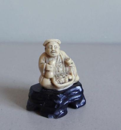 null JAPAN
Okimono ivory style representing a seated merchant in a suit
H.: 3,5 cm...