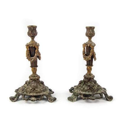 null Pair of candlesticks with two patinas. The fluted barrel with garlands of flowers....