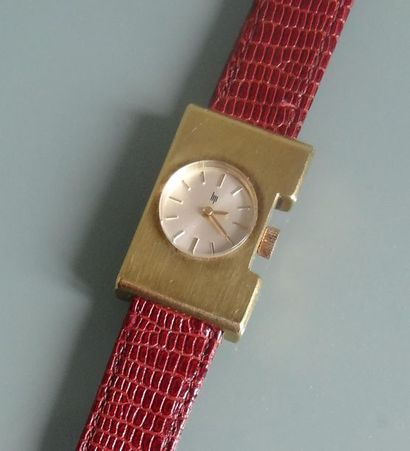 null LIP
Lady's watch with rectangular case in brushed gold metal. Round dial with...