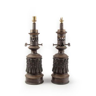 null Pair of kerosene lamps made of sheet metal with a fluted base. Middle 19th
century...