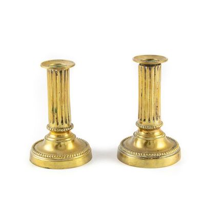 null Pair of small bronze toilet candleholders with fluted shaft and chiselled base...