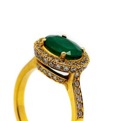 null Yellow gold ring adorned with an emerald surrounded by a pavement of small diamonds.
Gross...