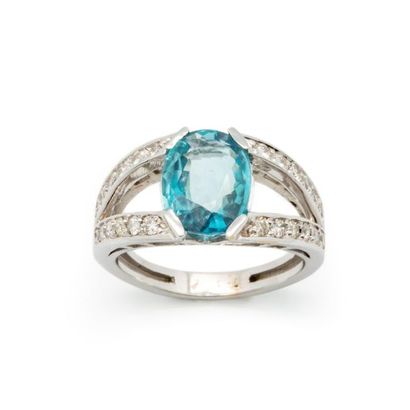 null Bague en or gris ornée d'un zircon bleu pesant environ 6 cts serti entre deux...