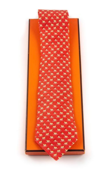 HERMES HERMES - Paris
Cravate en soie naturelle à fond rouge orangé orné de canard
L....