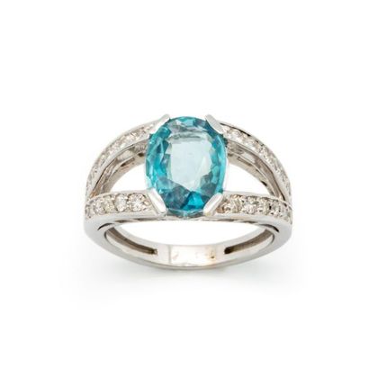 null White gold ring set with a blue zirconia weighing approximately 6 cts set between...