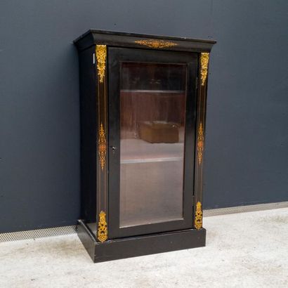 null Blackened wood veneer and gilt bronze ornaments. It opens by a glass door. Late...