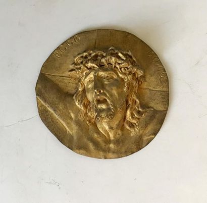 null Médaille en métal doré à décor repoussé	 représentant une tête de Christ. 
D....